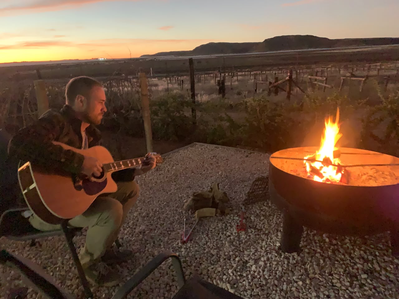 Guitar music beside a fire in the vineyard at sunset